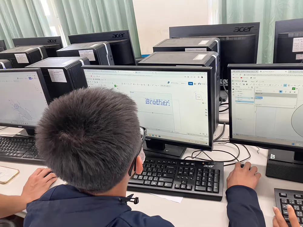 孩子坐在電腦前，螢幕上是正在用 TinkerCAD 畫的 3D 圖形